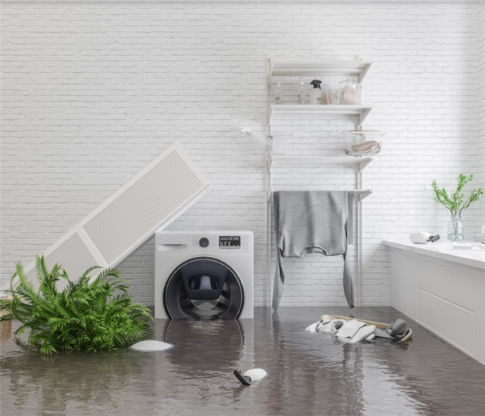 a flooded laundry room with water covering the floor and things floating everywhere
