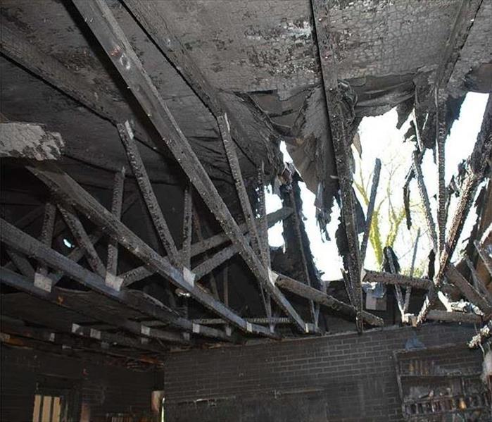 Fire damaged roof and truss burn to a char